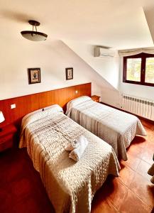 two beds in a hotel room with a stuffed animal on the bed at Hotel Puente de Piedra in Zamora