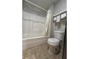 a bathroom with a toilet and a bath tub at Gazelle Stay by Hotel O Socorro in Socorro