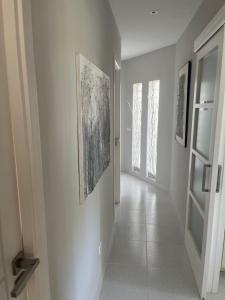 a hallway with paintings on the walls and a door at Minerva Beach in Port d'Alcudia