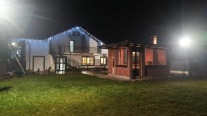 a house lit up at night with lights at Cerma Bucovina in Marginea