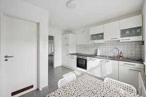 a kitchen with white cabinets and a table and chairs at Worker Place Lennestadt in Lennestadt