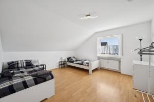 a white bedroom with two beds and a window at Cosy Worker Apartment Olpe in Olpe