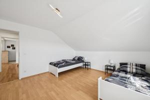 a white room with two beds and a couch at Cosy Worker Apartment Olpe in Olpe +9 photos