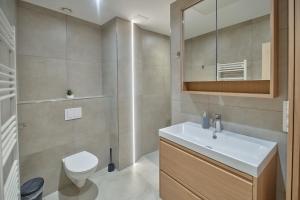 a bathroom with a white sink and a toilet at Riverside Holiday in Eupen