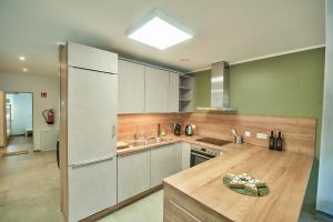 a kitchen with white cabinets and a wooden counter top at Riverside Holiday in Eupen +16 photos