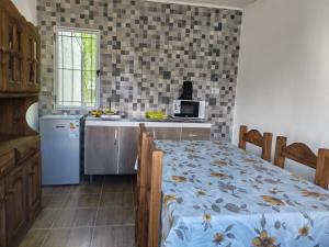 a kitchen with a refrigerator and a table with a bed at Finca Los Arrieros - Malargüe in Malargüe