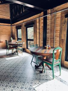 a dining room with a table and chairs and windows at LA PIANTA - Seu refúgio na Vila de Monte Verde in Monte Verde