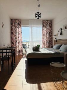 a bedroom with a large bed and a large window at Apartmány Júlia in Živogošće
