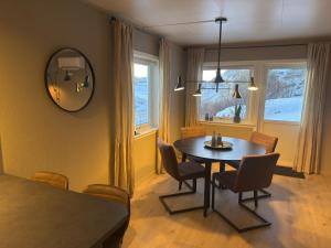 a dining room with a table and chairs and a mirror at Fishermans Villa Ballstad - Lofoten in Ballstad