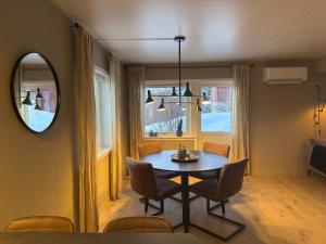a dining room with a table and chairs and a mirror at Fishermans Villa Ballstad - Lofoten in Ballstad