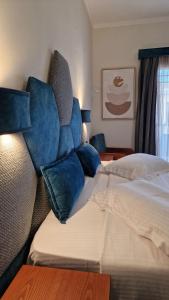 a hotel room with a bed with blue pillows at Hotel Dionysis Studios in Adamantas