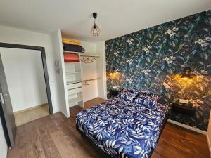 a bedroom with a bed and a tropical wallpaper at Maison La p'tite des Got - Terrasse & Parking in Viriat +14 photos