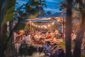 people sitting at tables in a restaurant at night at Kon Tiki in Saint-Tropez +150 photos
