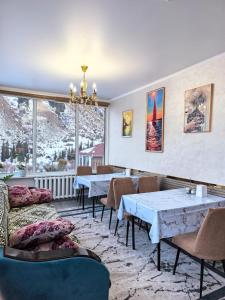a restaurant with tables and chairs and snow covered mountains at Кольсайские озера, гостиница Айару in Kurmenty