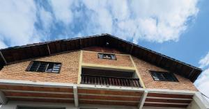 a brick building with three windows on top of it at Deruci Chale in Nova Friburgo