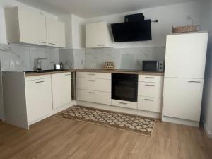 a kitchen with white cabinets and a white refrigerator at Lina Ferienhaus in Longkamp
