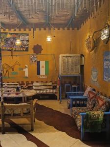 a room filled with furniture and paintings on the wall at Miral Nubian House in Aswan