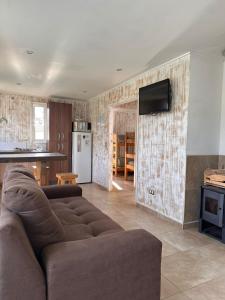 a living room with a couch and a kitchen at De Peppino Cabañas in Papudo