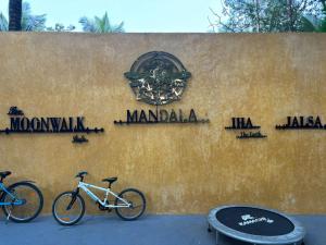two bikes parked next to a wall with signs on it at Mandala Resort in Sondekoppa
