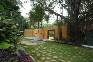 a courtyard with a large tree and a building at Mandala Resort in Sondekoppa