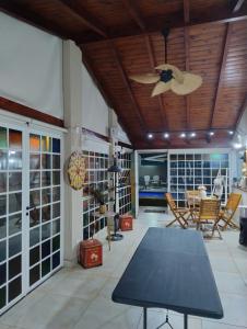 a living room with a table and a ceiling fan at Miranda House in Estancia San Ramon