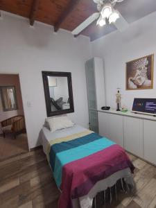 a bedroom with a bed with a colorful blanket at Miranda House in Estancia San Ramon +33 photos
