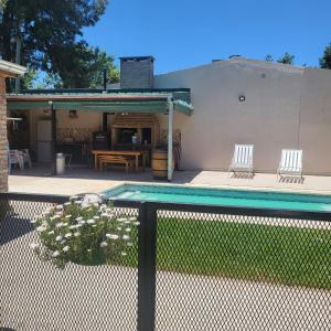 a swimming pool with two chairs and a table at Miranda House in Estancia San Ramon