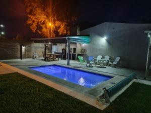 a swimming pool in a backyard at night at Miranda House in Estancia San Ramon