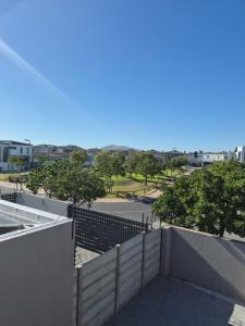 a view of a building with a fence and trees at Blouberg Guest suite, 3 km to the beach, Wi-Fi inc in Parklands