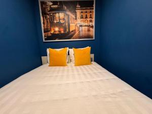 a bed with two orange pillows in a blue room at Studio Sto Antonio Alfama in Lisbon