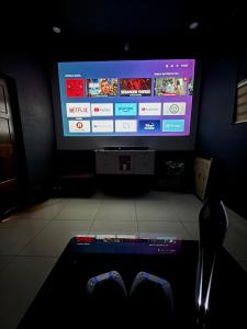a living room with a television and a remote control at Luxury Villa Ps5 Home-Theater Hookah 30km 2 Munnar in Chillithodu