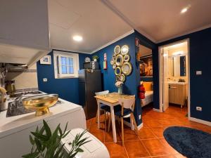 a kitchen with blue walls and a table with a sink at Studio Sto Antonio Alfama in Lisbon