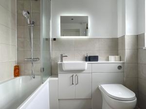 a bathroom with a sink and a toilet and a tub at HNFC Stays - Shoreline Flat in South Shields