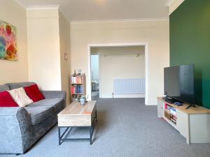 a living room with a couch and a flat screen tv at HNFC Stays - Shoreline Flat in South Shields
