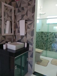 a bathroom with a sink and a glass shower at Recanto das Oliveiras in Corumbau +24 photos