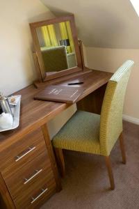 a wooden desk with a mirror and a chair at Redesdale Arms Hotel in Moreton in Marsh