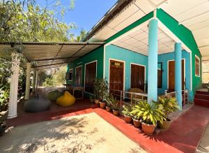 a blue and green house with plants on a patio at The Bunker Hostel Ella in Ella