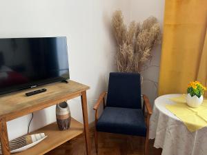 a room with a table with a tv and a chair at Wolność in Elblag
