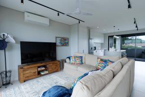 a living room with a couch and a flat screen tv at Husk 17 - Sheffield Beach in Ballito