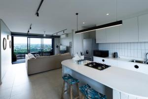 a kitchen and living room with a couch and a counter at Husk 17 - Sheffield Beach in Ballito
