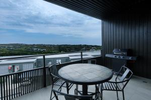 a table and chairs on a balcony with a view at Husk 17 - Sheffield Beach in Ballito