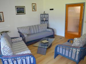 a living room with blue chairs and a couch at FEWO Weber in Lukowitz