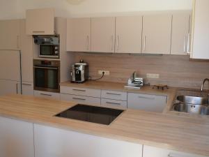a kitchen with white cabinets and a wooden counter top at FEWO Weber in Lukowitz +15 photos