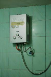 a soap dispenser on a wall in a bathroom at Swindo Homestay 77, Small House in Berastagi