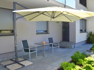 a table and chairs under an umbrella on a patio at FEWO Weber in Lukowitz