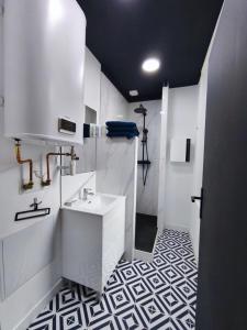 a bathroom with a white sink and a black ceiling at L'Artiste in Chauny