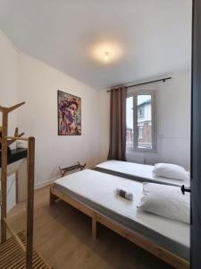 a bedroom with two beds and a window at L'Artiste in Chauny