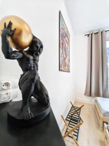 a statue of a woman holding a ball on a table at L'Artiste in Chauny