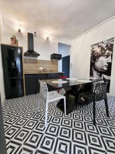 a dining room with a table and chairs and a kitchen at L'Artiste in Chauny