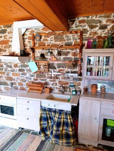 a kitchen with a sink and a brick wall at Moonstone retreat in Mesokhória